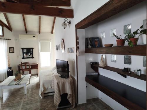 Una habitación con una cama y un televisor en la pared. en Casita Alpha, en San Pedro