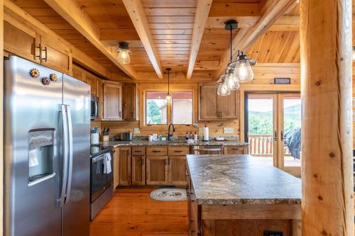 a kitchen with a stainless steel refrigerator and wooden cabinets at Chasing Clouds Cabin in Todd