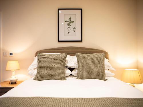 a bedroom with a bed with two lamps and a picture at Olivers Barn - Uk42081 in East Garston