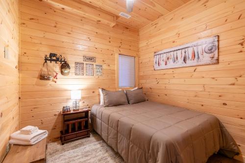 a bedroom with a bed in a wooden cabin at Chasing Clouds Cabin in Todd