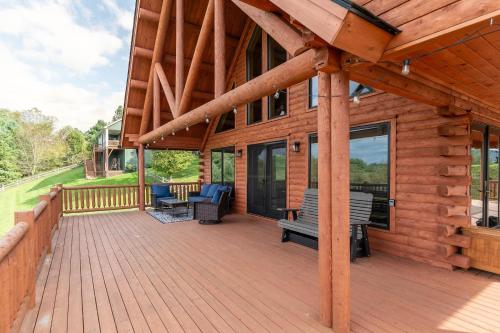 a wooden deck with benches on a house at Chasing Clouds Cabin in Todd