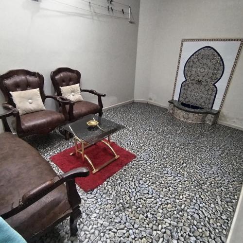 a living room with two chairs and a mirror at Maison d'hôte Najah 1 in Khenifra