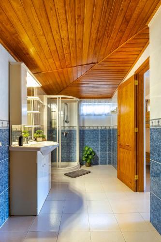 a bathroom with a sink and a shower with blue tiles at 3BR Tauro Bungalow - Garden, Terrace, Sleeps 6 in Mogán
