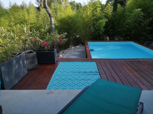 サン・ジェリー・デュ・フェスにあるSuperbe T3 avec jardin et bassin, dans un village calme au nord de Montpellierの木製デッキの大型スイミングプール