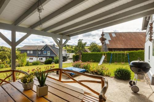 a patio with a wooden bench and a playground at Ferienwohnung Lichte in Medebach