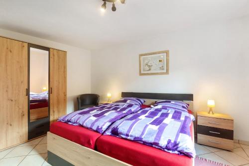 a bedroom with a bed and a chair and a mirror at Ferienwohnung Lichte in Medebach