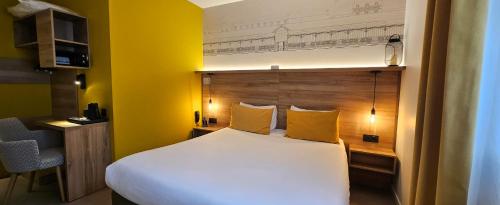 a bedroom with a white bed and a yellow wall at Hôtel des Halles in Dijon