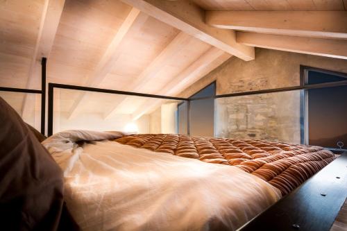 a large bed in a room with a wooden ceiling at Loft e Veranda sul Lago di Como in Blevio