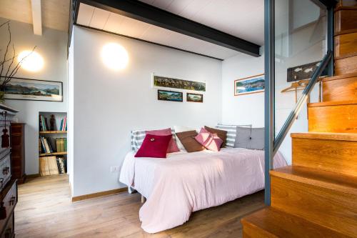 a bedroom with a bed with red pillows on it at Loft e Veranda sul Lago di Como in Blevio