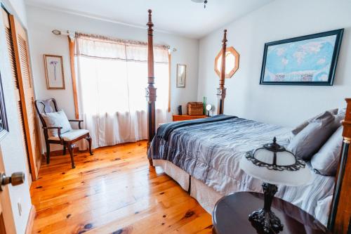 a bedroom with a bed and a table and a window at Speedway Log Cabin in Sebring