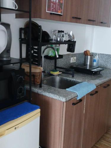 a kitchen with a sink and a counter top at Laidback Cavern at Studio City Alabang in Manila