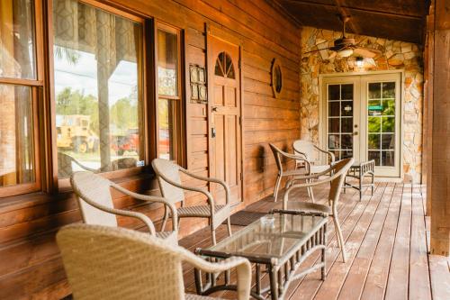a group of chairs and a table on a porch at Speedway Log Cabin in Sebring