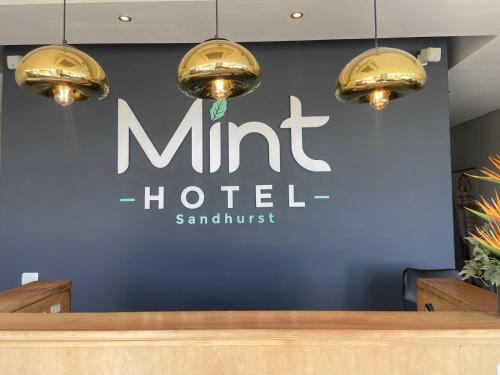 a sign for amt h hotel on a blue wall at Mint Hotel Sandhurst in Johannesburg