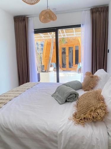 a bedroom with a large white bed with a window at lumbung asmara in Singaraja