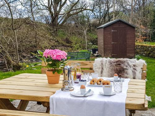 une table en bois avec une assiette de beignets dessus dans l'établissement Weavers Cottage, à Kenmore