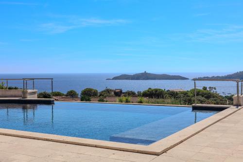 Una gran piscina con vista al agua. en Villa Ghjiseppina Di Pinarello, en Pinarellu