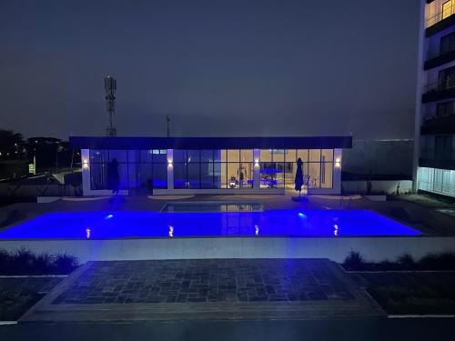 a large blue swimming pool in front of a building at night at Jkia luxury Apartments in Nairobi