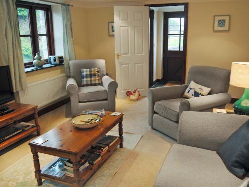 een woonkamer met banken en een salontafel bij Prideaux Cottage in Luxulyan