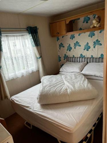 a bed in a small room with a window at Coastfield Holiday Village - Holiday Accommodation 17403 in Ingoldmells