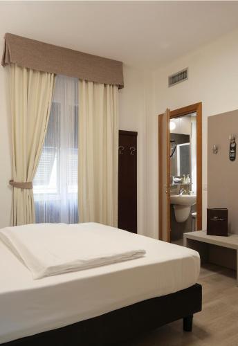 a bedroom with a bed and a sink and a window at Hotel Margherita in Monterosso al Mare