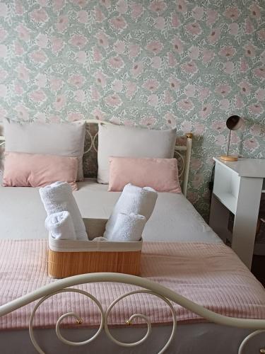 a bedroom with a bed with pink and white pillows at L'Epicerie Maison années 30 in Caen
