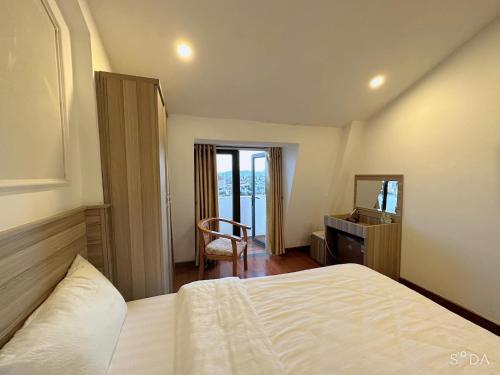 a bedroom with a bed and a desk and a mirror at Lina Hotel in Khu Chi Lăng