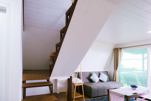a living room with a couch and a staircase at SUNYA Doichang in Ban Huai Khai
