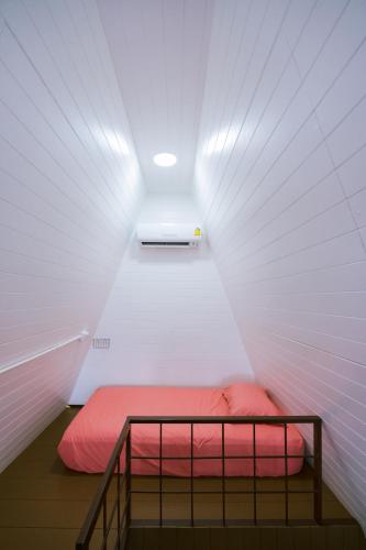 a small room with a bed in a white wall at SUNYA Doichang in Ban Huai Khai