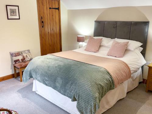 a bedroom with a large bed with pink pillows at Herrock View in Evenjobb