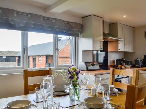 a kitchen with a table with plates and flowers on it at Hillside Cottage in Hanmer