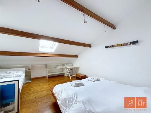 a white room with two beds and a tv at Wimereux, maison familiale entre plage et campagne in Wimille