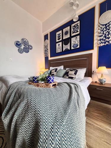 a bedroom with a bed with blue and white walls at Livora Escapes in Greater Noida