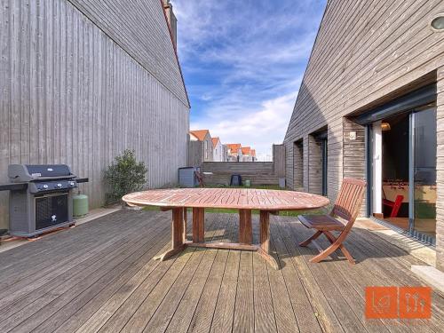 a wooden table on a deck with a grill at Wimereux, maison familiale entre plage et campagne in Wimille