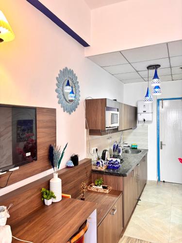 a kitchen with wooden cabinets and a counter top at Livora Escapes in Greater Noida