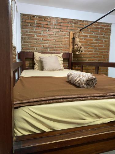 a bed in a room with a brick wall at PaddyView by Zzz in Banyuwangi