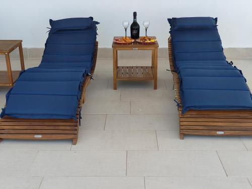 two beds with blue cushions and a table with a bottle of wine at CconfortHotels Sea Dream Palace 1 in Trani
