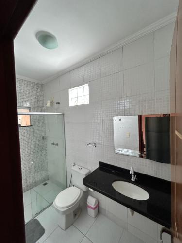 a bathroom with a toilet and a sink and a shower at Condomínio Il Sole - apartamento 1 in Porto Seguro
