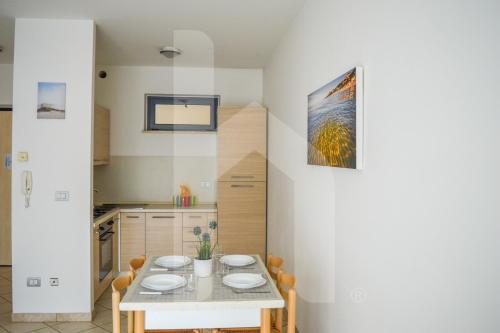 ein Esszimmer mit Tisch und eine Küche in der Unterkunft Homiday - Green Bay Village in Pineto