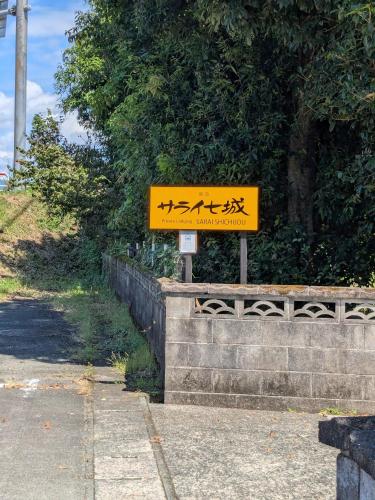 a yellow sign with chinese writing on it at 民泊サライ七城 in Kikuchi
