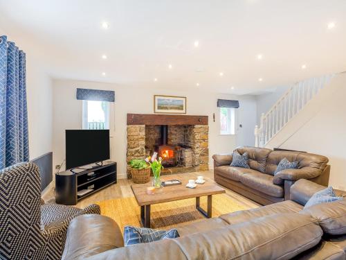 a living room with leather furniture and a fireplace at Gwel Y Castell - Uk48828 in Harlech