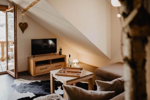 a living room with a tv and a table at Kirnermarteshof in Oberried