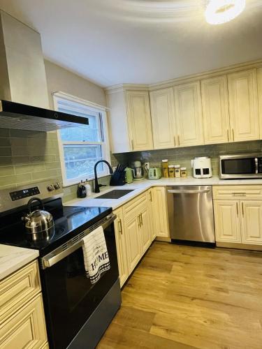 a kitchen with white cabinets and a black stove top oven at Private Estate, Walk to Princeton Downtown, 3-Bedrooms 2-Bath with Free Parking in Princeton