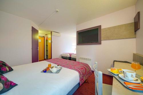 Ένα ή περισσότερα κρεβάτια σε δωμάτιο στο Brit Hotel Les Evens