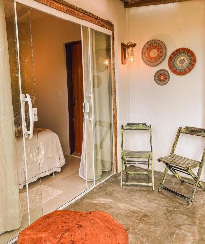 a room with a mirror and a chair and a bed at Aruana Despertar na Natureza a 5km da vila de Praia do Forte in Praia do Forte