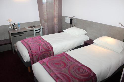 Ένα ή περισσότερα κρεβάτια σε δωμάτιο στο Brit Hotel Les Evens