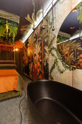 a bathroom with a black tub and a mural at Mint Hotel Sandhurst in Johannesburg