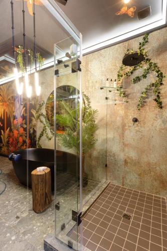 a bathroom with a bath tub and a wall with plants at Mint Hotel Sandhurst in Johannesburg