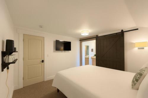 a bedroom with a white bed and a television at Snowcreek Suite - Ponderosa in Leavenworth