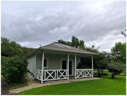 a small house with a porch on a green lawn at Domaine Saône-Valley in Traves