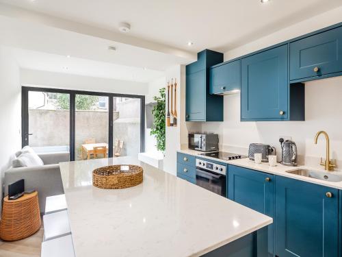 a kitchen with blue cabinets and a white counter top at Townhouse in Llandudno